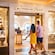 A man and a woman walking into the Treasures Untold upscale gift and accessories shop